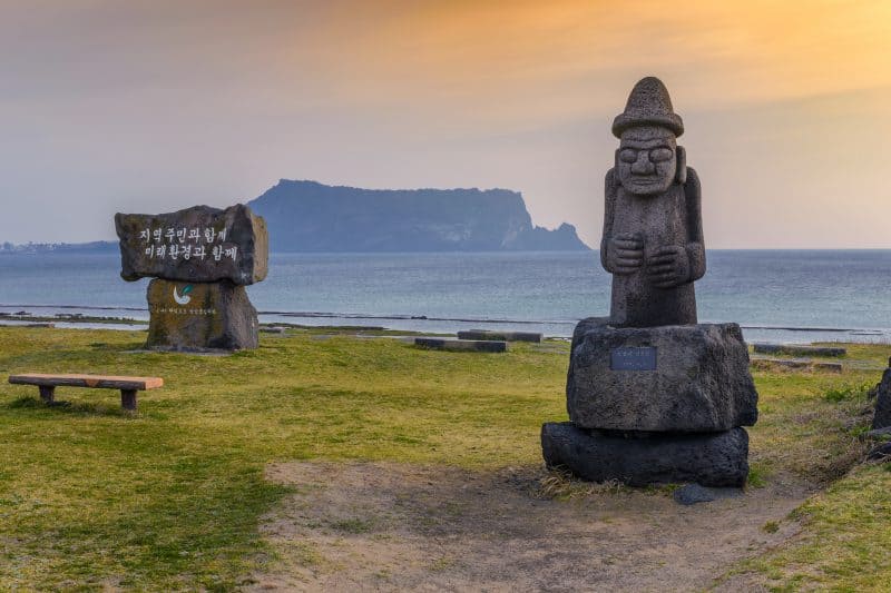 556876132 - รูปปั้น Dol hareubang และ Jeju do Seongsan Ilchulbong, เกาะเชจู, เกาหลี